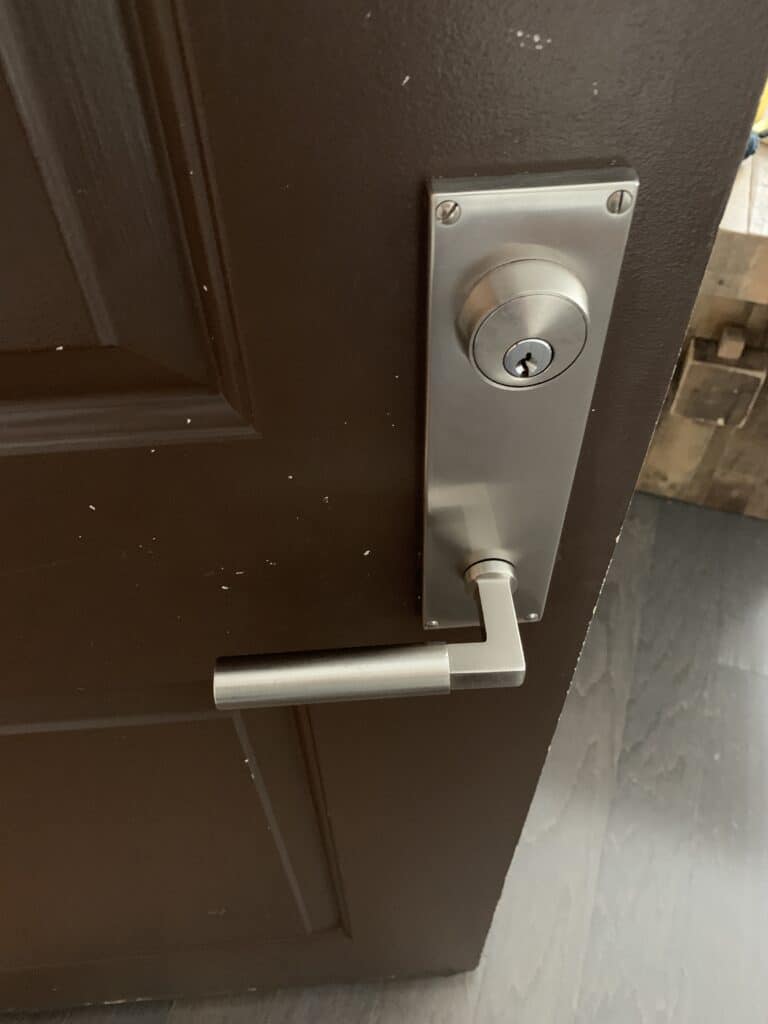 Residential door with a deadbolt and silver lever handle on Rogers Drive in West Falls Church, VA.